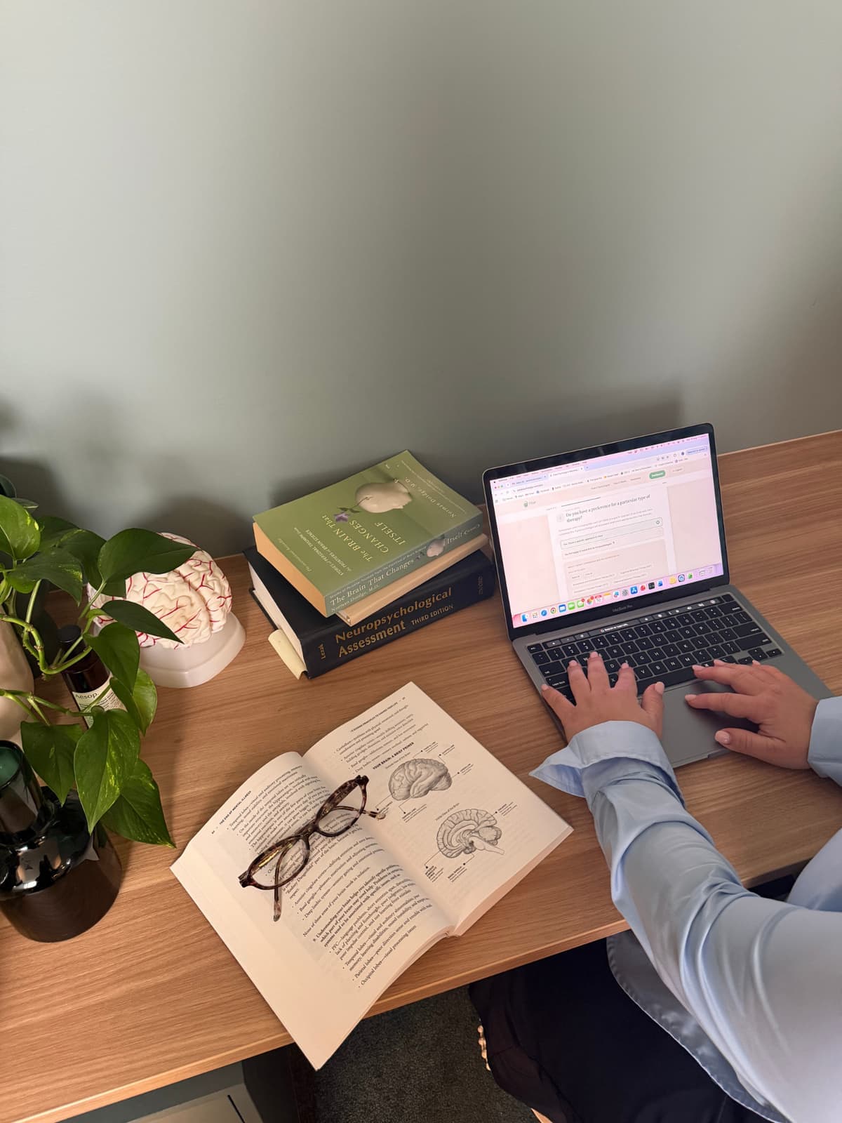 Desk with assessment texts and a laptop open to Pair
